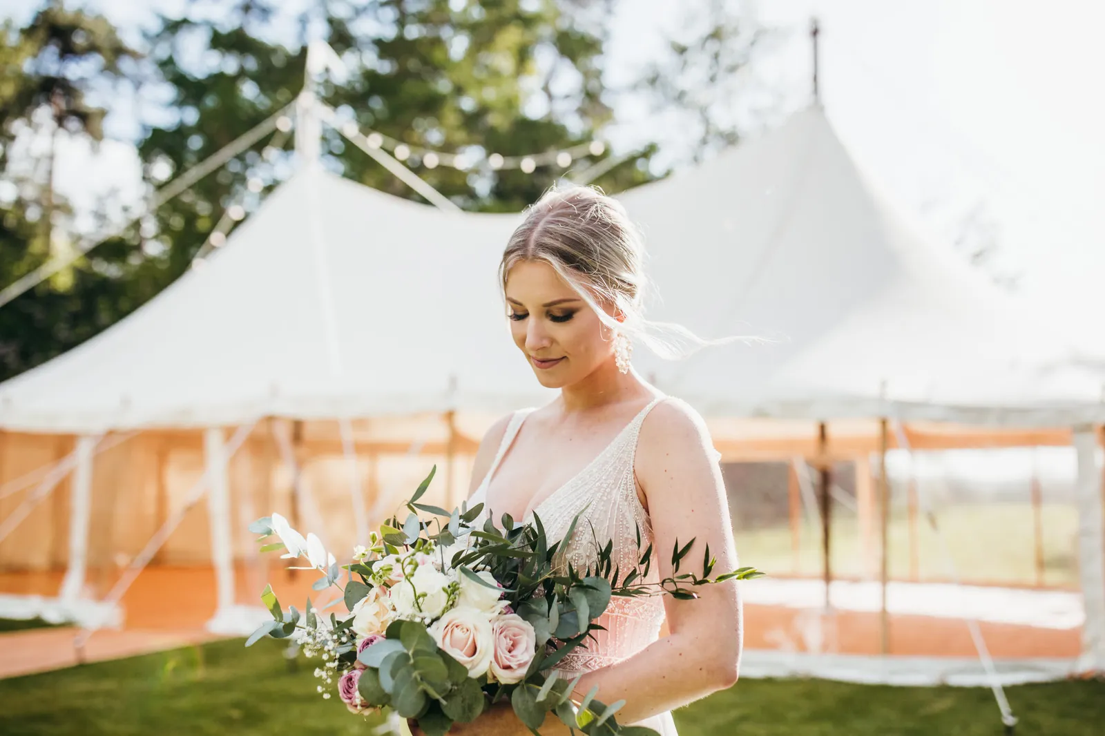 Bride holding a bouquet outside a marquee, hair and makeup by Jessica-Jade